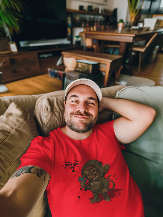 Homme détendu portant t-shirt rouge Artefacts avec design gaming sur canapé - lifestyle streetwear
